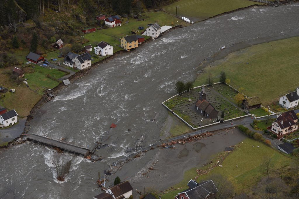 Store nedbørsmengder førte til flom i Flåmselva. Elva flommet inn over middelalderkirkegården og vannstanden sto over gulvet i kirka. Kirkas dekor og fundamenter kan ha blitt skadet. Også andre gamle bygg som har stått på tørt land i andre flomperioder ble denne gangen skadet. Foto: Helge Mikalsen/VG/NTB scanpix