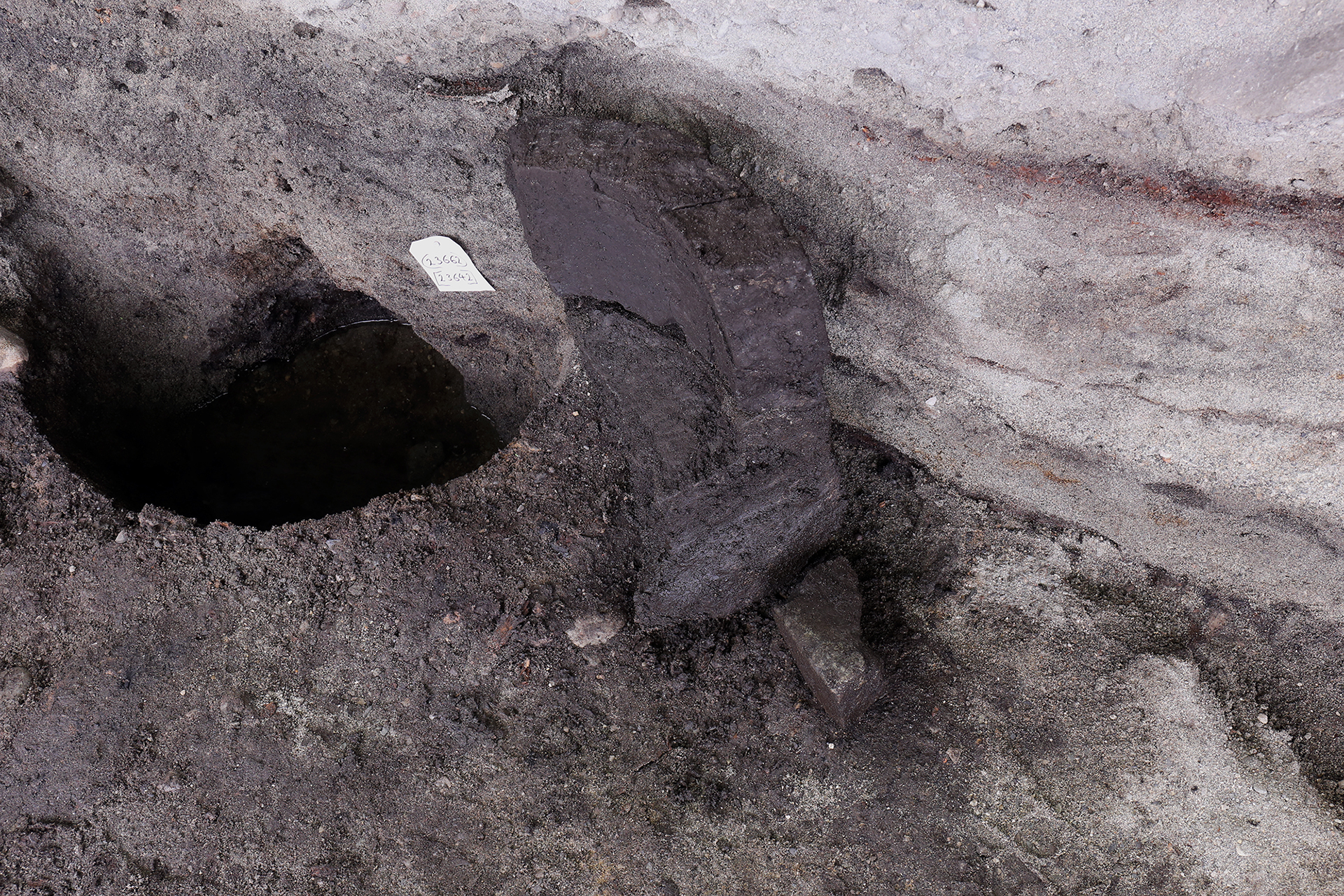 Bildet viser Deler av det som sannsynligvis er en døpefont. Flere deler fantes i andre stolpehull fra kirke 4. foto: Anna K. Wändahl, NIKU