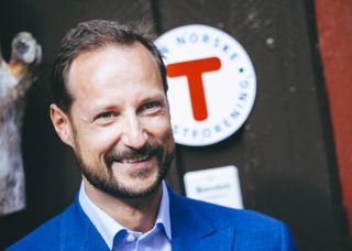 Kronprins Haakon foran DNT-skilt