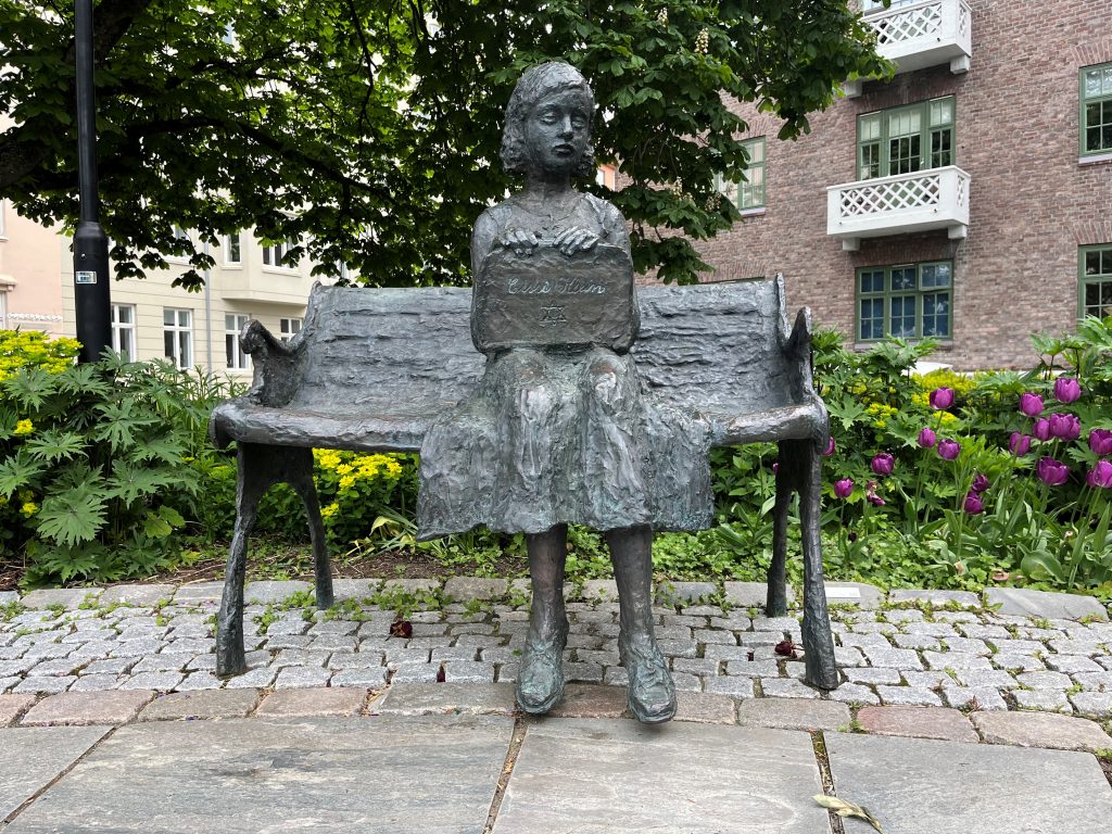 Statue av Cissi Klein, utført i bronse. Det er en benk der det sitter en ung pike med en veske i fanget med navnet hennes og Davidstjerna på. Føttene hennes rekker ikke helt ned til bakken, det er en del av symbolikken i verket.