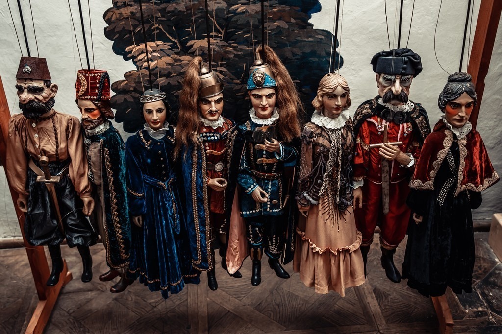En samling marionettdukker i tre med tradisjonelle kostymer.