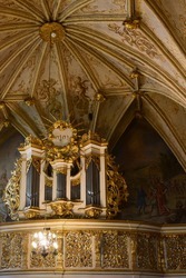 Bilde av et rikt utsmykket barokkorgel med lysekrone og hvelvet tak med gullornamenter