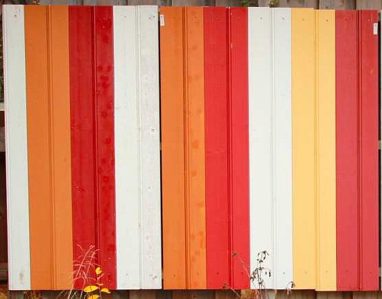 Oppstrøksprøver med linoljemaling på trepanel i oransje, rødt, hvitt og gult .